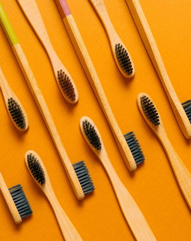 Close-up of bamboo toothbrushes on an orange background, emphasizing eco-friendly oral care.